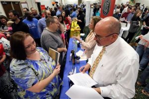 Frances Scoggins, left, speaks to Michael McCall, general manager for Chattanooga Labeling Systems, about her resume during a huge 15-county North Georgia job fair at The Colonnade in Ringgold, Ga., on Thursday, April 2, 2015. Scoggins has been unemployed for the past 4-months and is looking for a safety or manufacturing job. The U.S. government issues the March jobs report on Friday, April 3, 2015. (AP Photo/Chattanooga Times Free Press, Dan Henry)