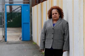 In this Thursday, April 23, 2015, photo Shalga Hightower, mother of  Iofemi Hightower, college student slain in 2007, poses for The Associated Press in the schoolyard where the murder happened in Newark, N.J. In the seven-plus years since her college-bound daughter's brutal slaying along with two friends in a case that became a national symbol of urban gun violence, Hightower has been on a mission. It started with a resolve to attend every court hearing involving the six men and boys eventually convicted for the crime, an odyssey that cost her her job and left her family temporarily homeless. Now, a documentary project is aiming to chronicle her struggles and her efforts on behalf of families of crime victims who are too often left to fend for themselves. (AP Photo/Julio Cortez)