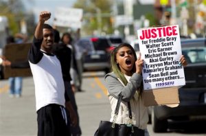 Caira Byrd hold support signs for Freddie Gray outside of Vaughn Greene Funeral Home, during his wake in Baltimore, Md., Sunday, April 26, 2015. Gray died from spinal injuries about a week after he was arrested and transported in a police van. (AP Photo/Jose Luis Magana)