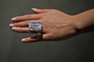 A Sotheby's employee models a 100-carat emerald-cut diamond, Friday, April 17, 2015, in New York. The "perfect" 100-carat diamond in a classic emerald cut is going on the auction block, where it could fetch between $19 million to $25 million. Sotheby's will offer the white diamond on April 21, in New York.  (AP Photo/Mary Altaffer)