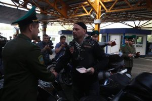 Belarus border guard shakes hands with a Russian biker as he checks his passport at Brest border check point on Belarus-Polish border on Monday, April 27, 2015. The bikers, including members of the Night Wolves group, set off from Moscow on Saturday with the aim of crossing into Poland before eventually reaching Berlin on 9 May. They are undertaking the journey despite Poland announcing it will refuse them entry into the country.  (AP Photo/Sergei Grits)