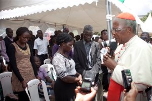 John Njue, right, Cardinal of the Roman Catholic Church and current Archbishop of Nairobi, prays with some of the relatives of students killed last Thursday in the Garissa University attack, Wednesday, April 8, 2015. Some Kenyan relatives of students who were killed in an attack by Islamic militants say they will offer prayers of forgiveness for the killers, responding to an appeal for compassion from an archbishop who visited a morgue where victims' bodies are being kept. (AP Photo/Sayyid Azim)