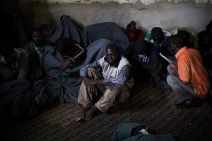FILE - In this file photo taken Friday, Nov. 29, 2013, African migrants cover themselves with blankets, after being captured by the Libyan Coast Guard while on a boat heading to Italy, in a detention center for illegal migrants in Abu Salim district on the outskirts of Tripoli, Libya. Libyas chaos has turned it into a large and lucrative funnel attracting migrants desperate to make the dangerous sea voyage to Europe. With no central authority to stop it, business is booming, creating a vicious circle that only translates into more tragedies in the Mediterranean. (AP Photo/Manu Brabo, File)