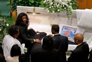 Gloria Darden, mother of Freddie Gray, is comforted as she embraces his body before his funeral, Monday, April 27, 2015, at New Shiloh Baptist Church in Baltimore. Gray died from spinal injuries about a week after he was arrested and transported in a Baltimore Police Department van. (AP Photo/Patrick Semansky)