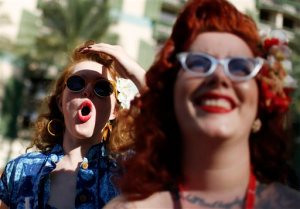 In this April 3, 2015, photo, Chelsea Spirito, left, reacts as she watches a men's bathing suit contest at the Viva Las Vegas Rockabilly Weekend in Las Vegas. Mae La Roux is on the right. (AP Photo/John Locher)