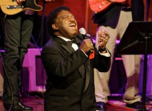 FILE - In this Oct. 28, 2008 file photo, Percy Sledge kneels as he performs "When a Man Loves a Woman" along with the Muscle Shoals Rhythm Section at the Musicians Hall of Fame awards show in Nashville, Tenn. Sledge, who recorded the classic 1966 soul ballad "When a Man Loves a Woman," died, Tuesday April 14, 2015. He was 74. (AP Photo/Mark Humphrey, File)