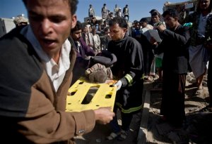 FILE - In this Thursday, March 26, 2015 file photo, people carry the body of a child they uncovered from under the rubble of houses destroyed by Saudi airstrikes near Sanaa Airport, Yemen. In just the first four days of fighting in Yemen, at least 62 children were killed by airstrikes or in clashes, UNICEF says, just one sign of the humanitarian damage being wreaked by the conflict in a country already gutted by years of chaos.(AP Photo/Hani Mohammed, File)