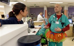 In this photo taken Tuesday, March 24, 2015, Dr. Bob Kaye, right, talks to registered nurse Nicole Maggi on Tutu Tuesday at Joe DiMaggio Childrens Hospital in Hollywood, Fla. (AP Photo/Alan Diaz)