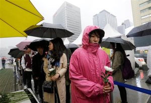 People wait to pay tribute to victims of the sunken ferry Sewol outside a temporary memorial altar in Seoul, South Korea, Thursday, April 16, 2015. Tears and grief mixed with raw anger Thursday as black-clad relatives mourned the 300 people, mostly high school kids, killed one year ago when the ferry Sewol sank in cold waters off the southwestern South Korean coast. (AP Photo/Ahn Young-joon)