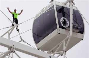Daredevil performer Nik Wallenda waves to a crowd below after he walked untethered along the rim of the Orlando Eye, the city's new, 400-foot observation wheel, Wednesday, April 29, 2015, in Orlando, Fla. The walk is being done in advance of next month's public opening of the attraction. (AP Photo/John Raoux)