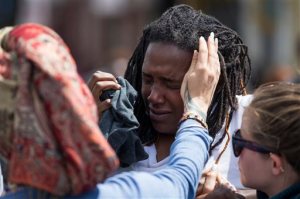 Shameeka Dream, of Baltimore is helped after being sprayed in the eyes with a crowd disbursement during a demonstration after an evening of riots following the funeral of Freddie Gray on Tuesday, April 28, 2015, in Baltimore. Gray died from spinal injuries about a week after he was arrested and transported in a Baltimore Police Department van. (AP Photo/Evan Vucci)