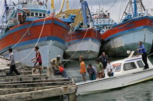 Burmese fishermen arrive at the compound of Pusaka Benjina Resources to report themselves for departure to leave the fishing company in Benjina, Aru Islands, Indonesia, Friday, April 3, 2015. Hundreds of foreign fishermen on Friday rushed at the chance to be rescued from the isolated island where an Associated Press report revealed slavery runs rampant in the industry. Indonesian officials investigating abuses offered to take them out of concern for the men's safety. (AP Photo/Dita Alangkara)