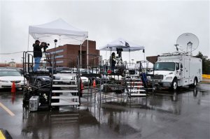 Television journalists work on platforms in the parking lot of the Arapahoe County Justice Center, on the first day of the trial of James Holmes, in Centennial, Colo., Monday, April 27, 2015. Holmes acknowledges killing 12 people and wounding 70 more inside a packed movie theater on July 20, 2012, but has pleaded not guilty by reason of insanity. (AP Photo/Brennan Linsley)