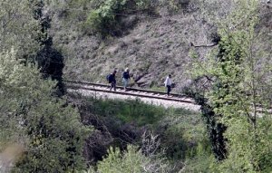 A group of migrants walk along the rail tracks north of the central Macedonian town of Veles, on Friday, April 24, 2015 near where 14 migrants were killed by a train while walking along the tracks. Fourteen migrants believed to be from Afghanistan and Somalia who were heading north toward the European Union were killed by an express train as they walked along tracks in central Macedonia Thursday night, police said Friday. (AP Photo/Boris Grdanoski)