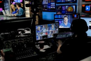 In this March 31, 2015 photo, co-hosts Beth Troutman, background left, and Oli Pettigrew film a segment on the set of the syndicated show "RightThisMinute", in Phoenix. The show gives viewers a daily dose of web videos and the story behind them. (AP Photo/Matt York)