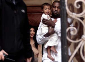 Kim Kardashian, a US reality TV star, and her husband Kanye West holding their daughter North West, walk inside Armenian St. James Cathedral, in Jerusalem, Monday, April 13, 2015. Kim Kardashian, along with husband West, their daughter, North West, and her sister, Khloe, arrived to Israel on a private visit.  (AP Photo/Mahmoud Illean)
