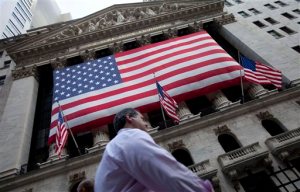 FILE - In this Monday, Aug. 8, 2011 file photo, a pedestrian walks past the New York Stock Exchange in New York. Stocks are opening slightly higher Monday, April 13, 2015, led by gains in the energy sector as the price of oil moves higher. (AP Photo/Jin Lee, File)