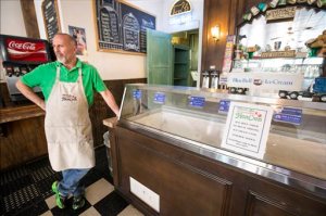 Charlie Pyle, owner of Must Be Heaven Ice Cream Parlor, stands by his ice cream case on Tuesday, April 21, 2015, in Brenham, Texas. In compliance with the Blue Bell Ice Cream recall, Pyle pulled all ice cream from his freezers. (Brett Coomer/Houston Chronicle via AP)
