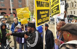 The Rev. Cortly "C.D." Witherspoon, front left, president of the Baltimore City chapter of the Southern Christian Leadership Conference, speaks at a protest outside City Hall about Freddie Gray in Baltimore, Monday, April 20, 2015. Baltimore's top police officials, mayor and prosecutor sought to calm a "community on edge" Monday while investigating how Gray suffered a fatal spine injury while under arrest. Six officers have been suspended, but investigators say they still don't know how it happened. (Amy Davis/The Baltimore Sun via AP)