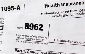 FILE - In this Aug. 21, 2014 file photo shows health care tax forms 8962 and1095-A, in Washington. As the April 15 tax deadline nears, people who got help paying for health insurance under President Barack Obama's law are seeing the direct effect on their refunds _ hundreds of dollars, for better or worse. With subsidies tied to income, consumers must accurately estimate what they will make for the coming year _ and that's been a challenge. Guess on the low side, get more help now with premiums, but owe money later at filing time. Overestimate income, expect bucks back from the taxman. (AP Photo/Carolyn Kaster)