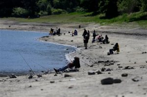People fish at San Pablo Reservoir Recreation Area in El Sobrante, Calif., Thursday, April 2, 2015. A spokeswoman for the East Bay Municipal Utility District said that the reservoir is about half full. California Gov. Jerry Brown ordered officials Wednesday, April 1, 2015 to impose statewide mandatory water restrictions for the first time in history as surveyors found the lowest snow level in the Sierra Nevada snowpack in 65 years of record-keeping. (AP Photo/Eric Risberg)