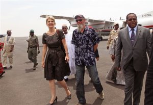 Released Dutch hostage Sjaak Rijke, second right, walks with an unidentified Dutch diplomat, center left, as he arrives at the airport in Bamako, Mali, Tuesday, April 7, 2015. French special forces on Monday freed Rijke who had been held hostage since being kidnapped in 2011 by extremists in Mali, the government said. There was no word on the fate of the two men who were abducted at the same time.(AP Photo/Baba Ahmed)