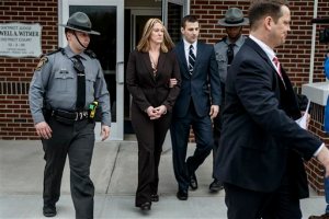 Hummelstown police officer Lisa J. Mearkle is escorted from District Judge Lowell Witmer's office, in West Hanover Township, Pa., after her preliminary arraignment, Tuesday, March 24, 2015, in the fatal shooting of David A. Kassick last month in South Hanover Township. Mearkle was charged Tuesday with criminal homicide after investigators concluded she shot the unarmed motorist in the back as he lay facedown after a traffic stop over an expired inspection sticker. (AP Photo/PennLive.com, Dan Gleiter)
