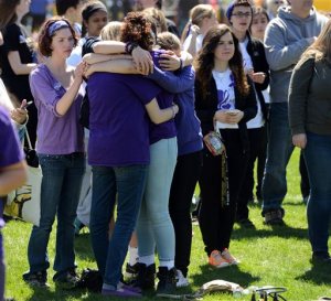 Friends embrace and remember Maren Sanchez Saturday, April 25, 2015, while listening to live music during the "Peace Love & Music From Maren" event at Jonathan Law High School in Milford, Conn. Saturday's celebration of Maren's life comes exactly one year after the 16-year-old was stabbed to death by a classmate at the high school.(Autumn Driscoll/The Connecticut Post via AP)