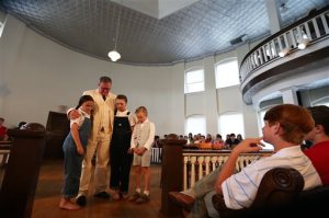  In this April 8, 2015 file photo, The Mockingbird Players perform "To Kill a Mockingbird," in Monroeville, Ala.  From left are Caroline Williamson, 10, as"Scout," Jeff Brock as "Atticus Finch", John Farish as  "Jim Finch" and Andrew Nettles as "Dill Harris."  A new group plans to produce a stage version of To Kill a Mockingbird." An actor in the play, Connie Baggett, said Friday, April 24, 2015, a new nonprofit group is working to obtain rights to the production and hopes to continue putting on Mockingbird with the same amateur actors whove been involved for years.