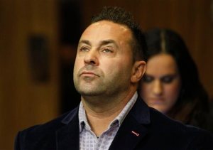 FILE - In this Oct. 15, 2014 file photo, Giuseppe "Joe" Giudice, from the television show "Real Housewives of New Jersey", stands during a hearing in the Passaic County Courthouse in Paterson, N.J.  Giudice lost his driver's license for two years as he's preparing to head to federal prison for bankruptcy fraud. A state judge on Thursday, April 2, 2015, called Giudice's driving record the worst he's ever seen. He also fined Giudice the maximum $10,000. Giudice pleaded guilty in October to unlawful use of an ID and impersonation. (AP Photo/The Star-Ledger, William Perlman, Pool)