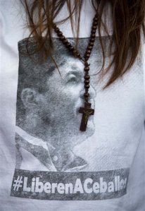 FILE - In this Friday, Jan. 23, 2015, file photo, San Cristobal's Mayor Patricia Gutierrez wears a rosary and a T-shirt with an image of her jailed husband Daniel Ceballos with a hashtag that reads in Spanish "Free Ceballos" at a protest in San Cristobal, Venezuela. Ceballos phoned his mother before dawn on Saturday, May 23, 2015 to say he'd been moved to a prison in San Juan de los Morros, according to his attorney. (AP Photo/Fernando Llano, File)