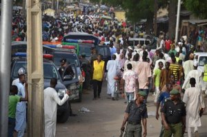 People throng the streets near the site of an explosion in Maiduguri, Nigeria, Saturday, May 30, 2015. A bomb exploded Saturday afternoon near Maiduguri's main market, after the city was attacked before dawn by Islamic extremists using rocket-propelled grenades, that killed at least 13 people, according to reports from local residents.  (AP Photo/Jossy Ola)