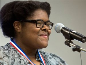ADVANCE FOR USE SUNDAY, MAY 17 - In this photo taken Friday, May 8, 2015, Johnessa Richard, 17, smiles after she receives the 2015 Governor's Medallion at the First College 10-year Celebration at Fred W. Beazley Portsmouth Campus in Portsmouth, Va. Johnessa will graduate from Tidewater Community College this month and next  month graduates from  I.C. Norcom High School. She plans to transfer to Old Dominion University this fall to major in biology. (The' N. Pham/The Virginian-Pilot via AP)  MAGS OUT