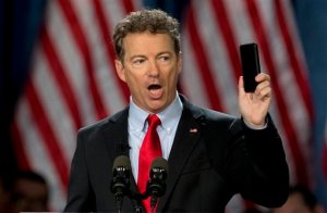 FILE - In this April 7, 2015 file photo, Sen. Rand Paul, R-Ky. holds up his cell phone as he speaks before announcing the start of his presidential campaign, in Louisville, Ky. The Justice Department warned lawmakers that the National Security Agency (NSA) will have to wind down its bulk collection of Americans' phone records by the end of the week if Congress fails to reauthorize the Patriot Act. The Republican divisions over the issue was on stark display in the Senate on Wednesday as Paul, a candidate for president, stood on the floor and spoke at length about his opposition to NSA spying.  (AP Photo/Carolyn Kaster, File)