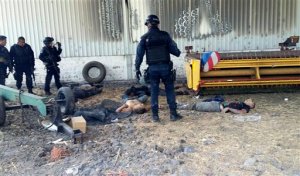 Federal police stand near the bodies of men who authorities say were suspected cartel gunmen at the Rancho del Sol, near Ecuanduero, in western Mexico, Friday, May 22, 2015. At least 43 people died Friday in what authorities described as a fierce, three-hour gunbattle between federal forces and suspected drug gang gunmen at the ranch. (AP Photo/Oscar Pantoja Segundo)