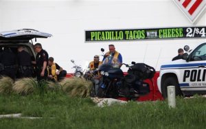 Police detain and watch members of various motorcycle clubs near a Twin Peaks restaurant in Waco, Texas, Sunday, May 17, 2015. A shootout among rival motorcycle gangs at the popular Texas restaurant left nine bikers dead and more than a dozen injured, a police spokesman said Sunday. (AP Photo/John L. Mone)