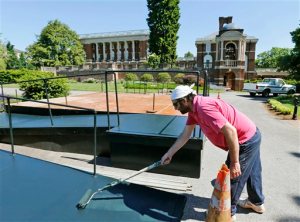 In this photo taken on Wednesday, May 13, 2015, Sweet Briar College employee, Steven Woody, paints the commencement stand at the school in Sweet Briar, Va. It will be a bittersweet commencement at Sweet Briar College as the 114-year-old womens college sends off what is likely its final class of graduates. The school is scheduled to close in August with the final commencement ceremonies Saturday, May 16.   (AP Photo/Steve Helber)