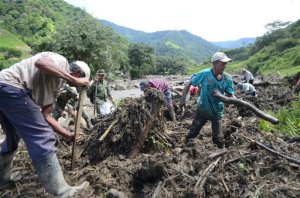 Residents look for survivors after and avalanche in Salgar, in Colombia's northwestern state of Antioquia, Monday, May 18, 2015. The avalanche of mud and debris roared down Salgar before dawn, killing at least 49 people in a flood and mudslide triggered by heavy rains. Survivors barely had enough time to gather their loved ones. (AP Photo/Luis Benavides)