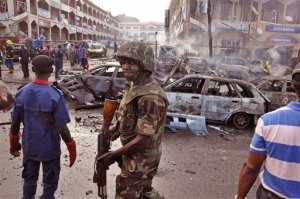 FILE - In this Wednesday, June, 25, 2014, file photo, a Nigerian soldier, center, walks at the scene of an explosion suspected to be set by Boko Haram extremist in Abuja, Nigeria. An alarming spike in suicide bombings by girls and women abused by Boko Haram in northeast Nigeria has children in danger of being seen as potential threats, the U.N. childrens agency said Tuesday, May 26, 2015. (AP Photo/Olamikan Gbemiga, File)