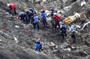 FILE - In this March 26, 2015 file photo, rescue workers work on debris of the Germanwings jet at the crash site near Seyne-les-Alpes, France. The Marseille prosecutor says Tuesday that death certificates for everyone aboard the doomed Airbus A320 jet have been signed and turned over to officials at German airline Lufthansa, parent company of the low-cost airline whose co-pilot intentionally crashed the aircraft into a mountain. (AP Photo/Laurent Cipriani, File)
