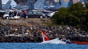 A US Navy aircraft sits in shallow water in San Diego Bay after over shooting a runway at the North Island Naval Station Friday, May 22, 2015 in San Diego. The pilot ejected and was reportedly picked up by a civilian craft. (AP photo/Lenny Ignelzi)