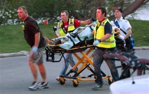 In this May 3, 2015 photo, authorities move Sergio Valencia del Toro, 27, to an ambulance following a shooting at a recreational bridge in the City of Menasha, Wis. Police say del Toro and his fiancee had recently called off their wedding and had argued before del Toto randomly shot four strangers before killing himself. Authorities say four are dead and one hospitalized in critical condition. (Duke Behnke/The Post-Crescent  via AP)