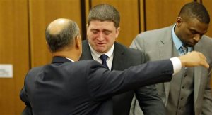 Michael Brelo hugs his attorney, Patrick DAngelo, after the verdict in his trial Saturday, May 23, 2015, in Cleveland. Brelo, a patrolman charged in the shooting deaths of two unarmed suspects during a 137-shot barrage of gunfire was acquitted Saturday in a case that helped prompt the U.S. Department of Justice determine the city police department had a history of using excessive force and violating civil rights. (AP Photo/Tony Dejak)