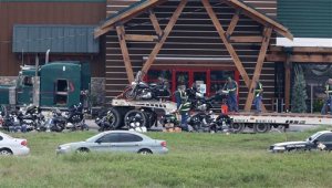 People load motorcycles on to a trailer in front of the Twin Peaks restaurant Monday, May 18, 2015, in Waco, Texas. About 170 members of rival motorcycle gangs were charged with engaging in organized crime Monday, a day after a shootout at the restaurant killed nine people and wounded 18. (AP Photo, Jerry Larson)