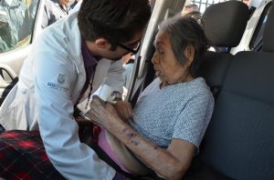 A paramedic attends an elderly woman after evacuating her from a nursing home that caught fire in Mexicali, Mexico, Tuesday, June 23, 2015. The fire killed more than a dozen elderly residents at the home, and the cause of the blaze was being investigated by the state prosecutors' office, according to Mexicali Mayor Jaime Diaz Ochoa. (AP Photo/Cristian Torres)