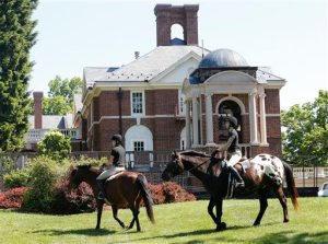 FILE This Wednesday May 13, 2015 file photo show graduating seniors at Sweet Briar college participate on the tradition Senior ride on the quad at the school in Sweet Briar, Va.   The senior ride is a tradition where seniors are allowed to ride horses on school grounds.  The Supreme Court of Virginia justices are scheduled to hear an appeal Thursday of a failed bid to block the small college from shuttering its picturesque Blue Ridge Mountains campus in August.  (AP Photo/Steve Helber)