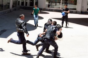Turkish riot police try to protect a person from a group of people of unknown affiliation who were attacking a rally of pro-Kurdish Peoples' Democracy Party, (HDP) in eastern city of Erzurum, Turkey, Thursday, June 4, 2015. Several people were injured and a HDP election campaign car was set on fire by attackers. Turkey will hold general election on June 7, 2015 and approximately 56 million Turkish voters are eligible to cast their ballots to elect the 550 members of the Grand National Assembly.(AP Photo)