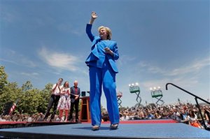 Democratic presidential candidate, former Secretary of State Hillary Rodham Clinton, right, acknowledges supporters as her husband, former President Bill Clinton, center right, their daughter Chelsea Clinton, center left, and her husband Marc Mezvinsky watch after a speech Saturday, June 13, 2015, on Roosevelt Island in New York. (AP Photo/Julio Cortez)