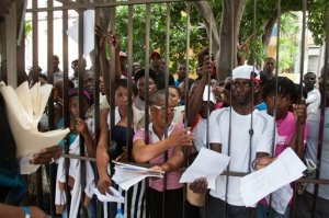 Migrants, mostly Haitians, show officers their documents as they wait their turn to register for legal residency at the Interior Ministry in Santo Domingo, Dominican Republic, Tuesday, June 16, 2015. The head of the immigration agency in the Dominican Republic says the country is ready to resume deporting non-citizens without legal residency after putting the practice on hold for a year. (AP Photo/Tatiana Fernandez)