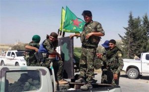 In this photo provided by the Kurdish fighters of the People's Protection Units (YPG), which has been authenticated based on its contents and other AP reporting, Kurdish fighters of the YPG, sit on their pickup in the town of Ein Eissa, north of Raqqa city, Syria, Tuesday, June 23, 2015. Kurdish fighters and their allies have captured an Islamic State group military base in northern Syria under the cover of U.S.-led airstrikes bringing them closer than ever to the extremists de facto capital of Raqqa, activists said Tuesday. (The Kurdish fighters of the People's Protection Units via AP)
